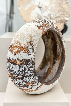 two white and brown vases sitting on top of each other