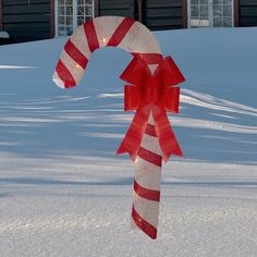 a candy cane in the snow with a red bow