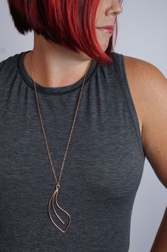 Soft curves form an elegant, handcrafted pendant on a long chain for the perfect pop for your every day style. Available in tarnish-resistant Argentium silver with a silver chain, matte black steel with an oxidized silver chain, or bronze with a bronze chain. Approximately 3 1/2" tall and 1 1/8" wide. Comes on a 30" long chain with clasp. Each necklace is handmade to order and may vary slightly from those shown. Please allow 2-3 days for your necklace to ship. Comes in a gift box tied with a rib Floral Tattoos, Georgia O Keeffe, O Keeffe, Argentium Silver, Oxidized Silver, Black Steel, Long Necklace, The Heat, Statement Earrings