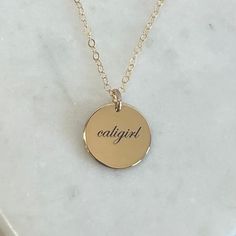 Not too big and not too small, our 13mm disc necklace, fits just right. A perfect everyday necklace that will layer beautifully with your other chain and pendant necklaces. Engrave a heartfelt word, a special year, or a name of a loved one. Free Engraving for a limited time! NECKLACE DETAILS *  14K Gold Filled (NOT PLATED) * Matching cable chain in your choice of 16", 18" or 20" length * Disc measures 13mm (.51") * Spring ring clasp closure * Choice of several fonts * Up to 8 characters will fit 14k Gold Hand Stamped Charm Necklaces With Round Pendant, Hand Stamped 14k Gold Round Pendant Charm Necklaces, Hand Stamped 14k Gold Charm Necklace With Round Pendant, Everyday 14k Gold Hand Stamped Necklaces, Everyday Engraved 14k Gold-filled Charm Necklace, Everyday 14k Gold Round Charm Necklaces, Everyday Engraved 14k Gold Filled Charm Necklace, Everyday 14k Gold Hand Stamped Necklace, Meaningful Gold Round Pendant Jewelry