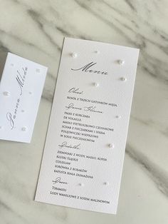 a white wedding program with pearls on it