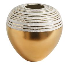 a gold and silver vase sitting on top of a white table