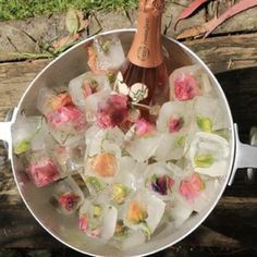 an ice bucket filled with flowers and a bottle of champagne