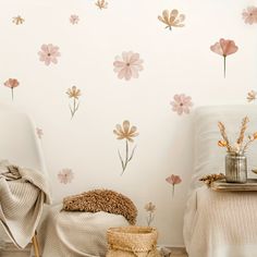 a bedroom with flowers painted on the wall next to a chair and other items in front of it