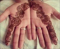 two hands with henna tattoos on them