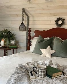 a bed with pillows and blankets on top of it next to a table with candles