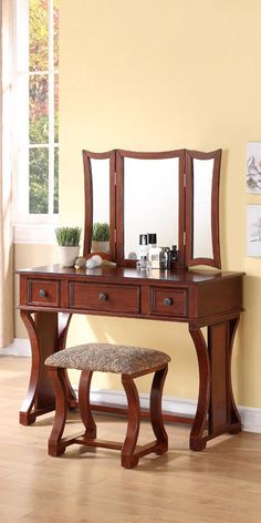 a wooden vanity table with mirror and stool