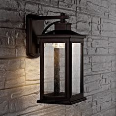 an outdoor light on the side of a brick wall