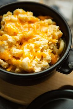 a black bowl filled with macaroni and cheese