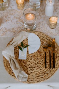 a table setting with place settings and candles