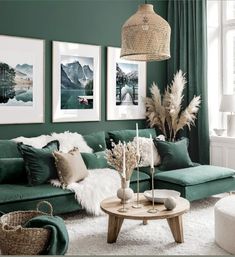 a living room with green walls and pictures on the wall above the couch, coffee table