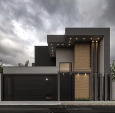 a modern house with two garages and lights on it