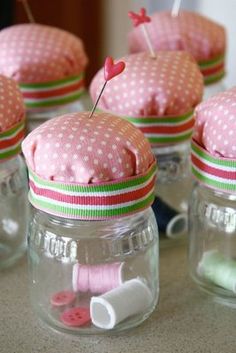 small jars with pink and green polka dots on them, each filled with different items