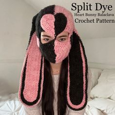 a woman wearing a pink and black crochet bunny mask