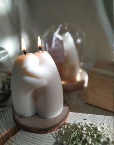 two candles sitting on top of a wooden stand