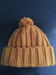 a brown knitted hat sitting on top of a blue surface