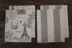 three pieces of fabric sitting on top of a wooden table next to each other, with the eiffel tower printed on them