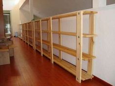 several wooden shelves lined up against the wall in a room with hard wood flooring