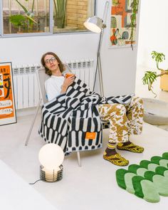 a woman sitting in a chair with a blanket over her