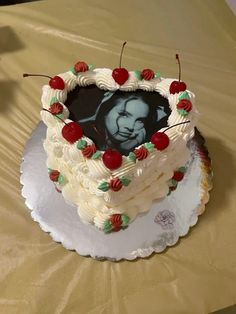 a heart - shaped cake with cherries and an image of a baby in the middle