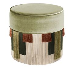 a round ottoman with tassels and fringe on the bottom, in green velvet