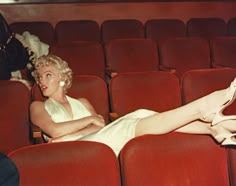 a woman laying on top of a red chair