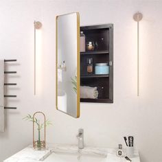 a bathroom with a sink, mirror and towel dispenser on the wall