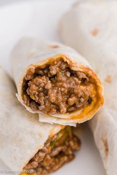 two burritos sitting on top of a white plate