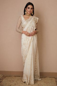 White scallop border saree with floral embroidery in sequin, cutdana and nakshi. Paired with embroidered, padded blouse and petticoat.
Components: 3
Pattern: Embroidered
Type Of Work: Nakshi, Cutdana, Sitara
Neckline: Scoop
Sleeve Type: Sheer
Fabric: Net, Crepe
Color: White
Other Details: 
Floral pattern
Back tassel tie-up
Occasion: Bride,Wedding - Aza Fashions White Saree Blouse, Astha Narang, White Sari, Long Blouse Designs, Bridal Sari, Scallop Border, India Dress, Padded Blouse, Border Saree