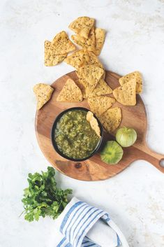 tortilla chips and salsa on a wooden cutting board