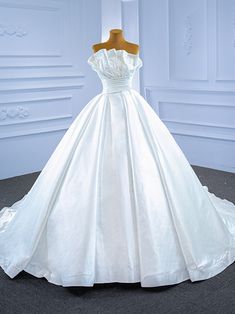 a white wedding dress on display in a room