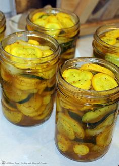 several jars filled with pickles sitting on top of a table