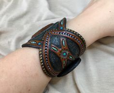 Handmade Turquoise Wearable Art Jewelry, Handmade Southwestern Turquoise Leather Bracelet, Artisan Turquoise Cuff Bracelet For Festivals, Brown Southwestern Jewelry With Patina, Southwestern Brown Jewelry With Patina, Artisan Handcrafted Brown Jewelry, Traditional Leather Jewelry For Festival, Hand Painted Bohemian Bangle Jewelry, Bohemian Hand-painted Bangle Jewelry