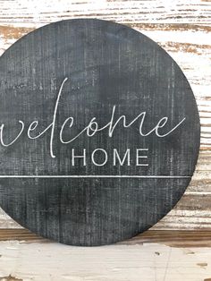 a welcome home sign hanging on the side of a wooden wall