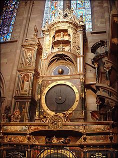 an ornate clock in front of a stained glass window