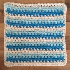 a blue and white crocheted dishcloth on a wooden surface