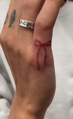 a woman's hand with a red ribbon tied around her wrist and the word love written on it