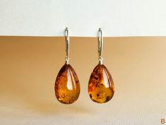 "Natural Baltic amber cognac color earrings is a perfect choice for classy style admirers! Perfect choice to brighten up office outfit or look even more beautiful on a special occasion! Shaped in drop form these earrings look delicate yet fancy. MATERIALS AND SIZE: Stone: 100% Natural Baltic Amber Findings: sterling silver 925 Earrings A: Weight: 6 g (0,21 oz) Bead size: 2,8 cm (1,1 in) x 1,4 cm (0,55 in) Total earring length: 4.9 cm (1,92in) Earrings B: Weight: 5,49 g (0,20 oz) Bead size: 2,3 c Classic Amber Earrings For Gift, Amber Dangle Earrings For Formal Occasions, Amber Drop Earrings For Formal Occasions, Elegant Amber Dangle Earrings, Elegant Amber Teardrop Earrings, Elegant Brown Teardrop Earrings For Gift, Elegant Brown Earrings For Party, Classic Amber Earrings For Formal Occasions, Elegant Brown Drop Earrings