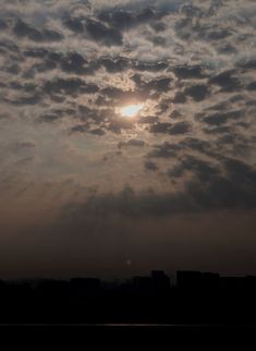 the sun is setting behind some clouds in the sky