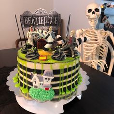 a halloween themed cake on a table next to a skeleton