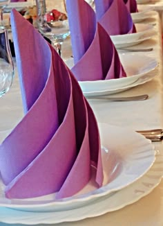 the table is set with purple napkins and silverware