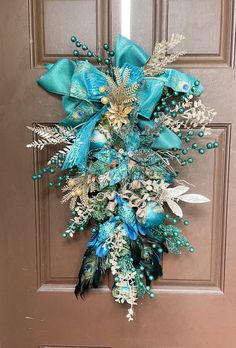 a door decorated with blue and green flowers, feathers and beads on it's side