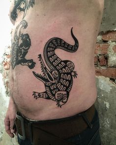 a man with a tattoo on his stomach that has a lizard on it's side