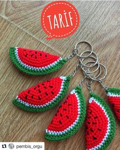 crocheted watermelon slice keychains are shown on a wooden table