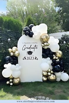 graduation balloon arch with black and white balloons in the shape of a graduate's cap