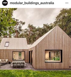 an image of a wooden house in the middle of some green grass with trees around it