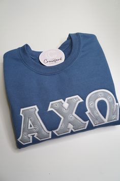 a blue shirt with the letters axxo on it