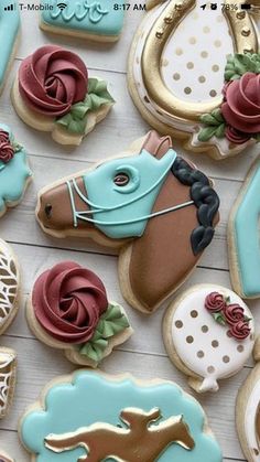 decorated cookies are arranged on a table with horse and rose decorations in the shape of horseshoes