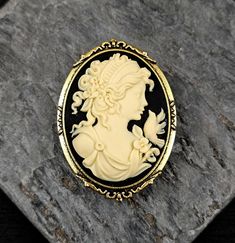 A beautiful cream cameo with a black background set in detailed antiqued gold. Cameo features a detailed Victorian girl with flowers, curls in her hair and a small bird on her shoulder. Details: *Measures approx 2.25 x 2 inches *Secure, locking pin back  *Cameo is made of a hard, matte resin *Setting is plated brass Please allow for possible slight color differences due to different settings on different screens. Thank you for shopping Delicate Industry :) Black Cameo, Unique Christmas Gift, Cameo Jewelry, Holiday Gift Ideas, Cameo Brooch, Jewelry Unique, Unique Christmas Gifts, Small Birds, Pin Backs