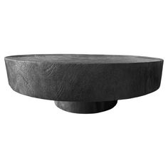 a black round table with a circular base on it's side, against a white background